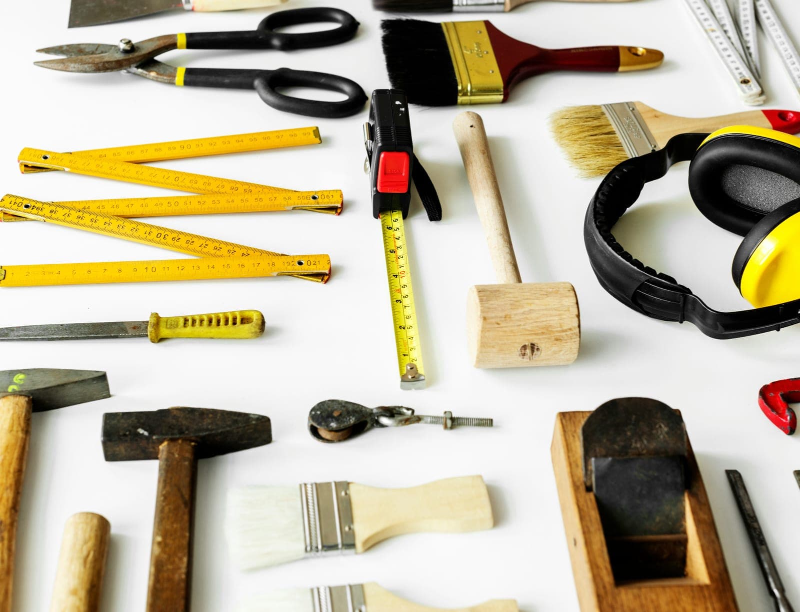 Yellow hand tools laid out on a white background